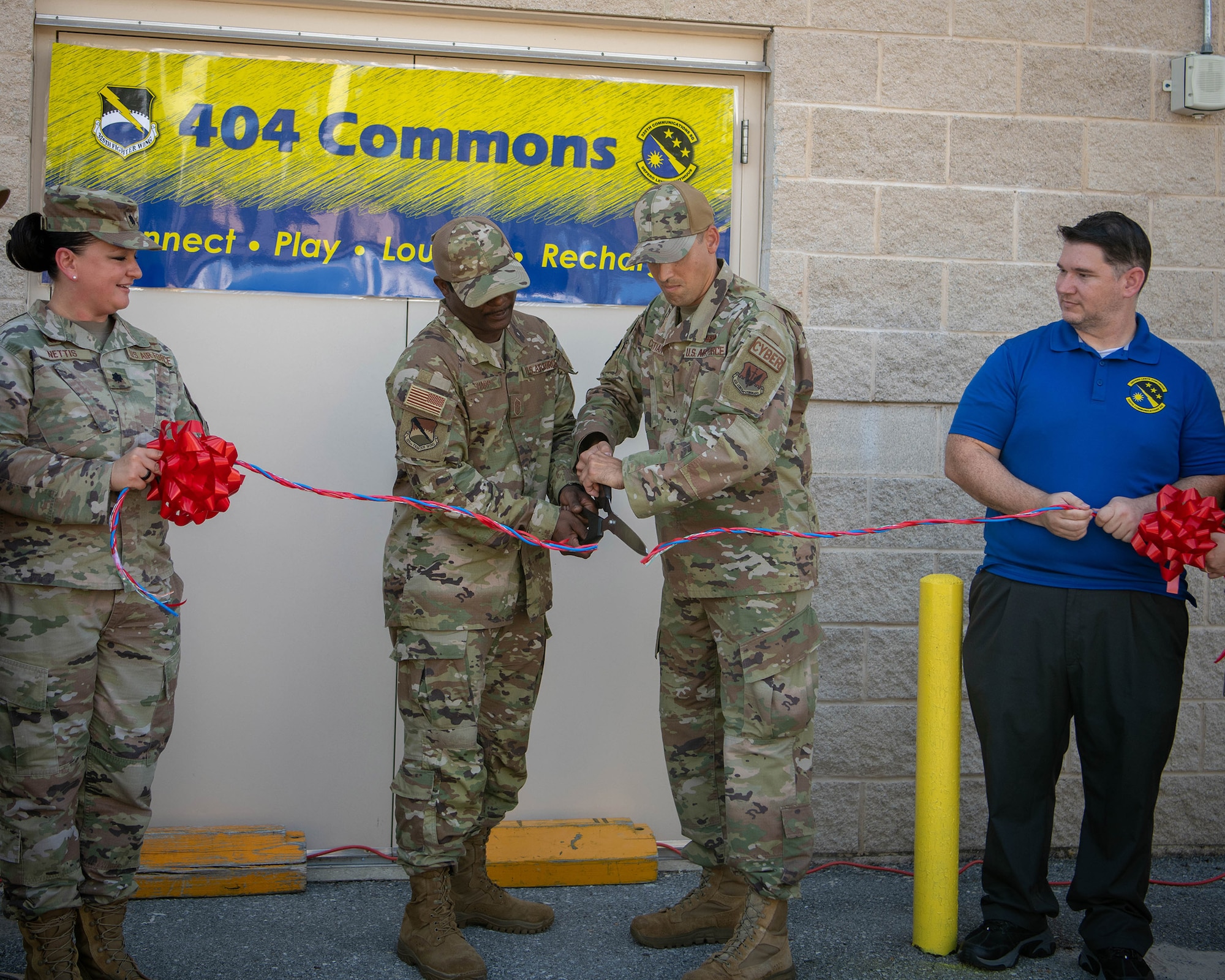 Two uniform members cut a ceremonial ribbon.