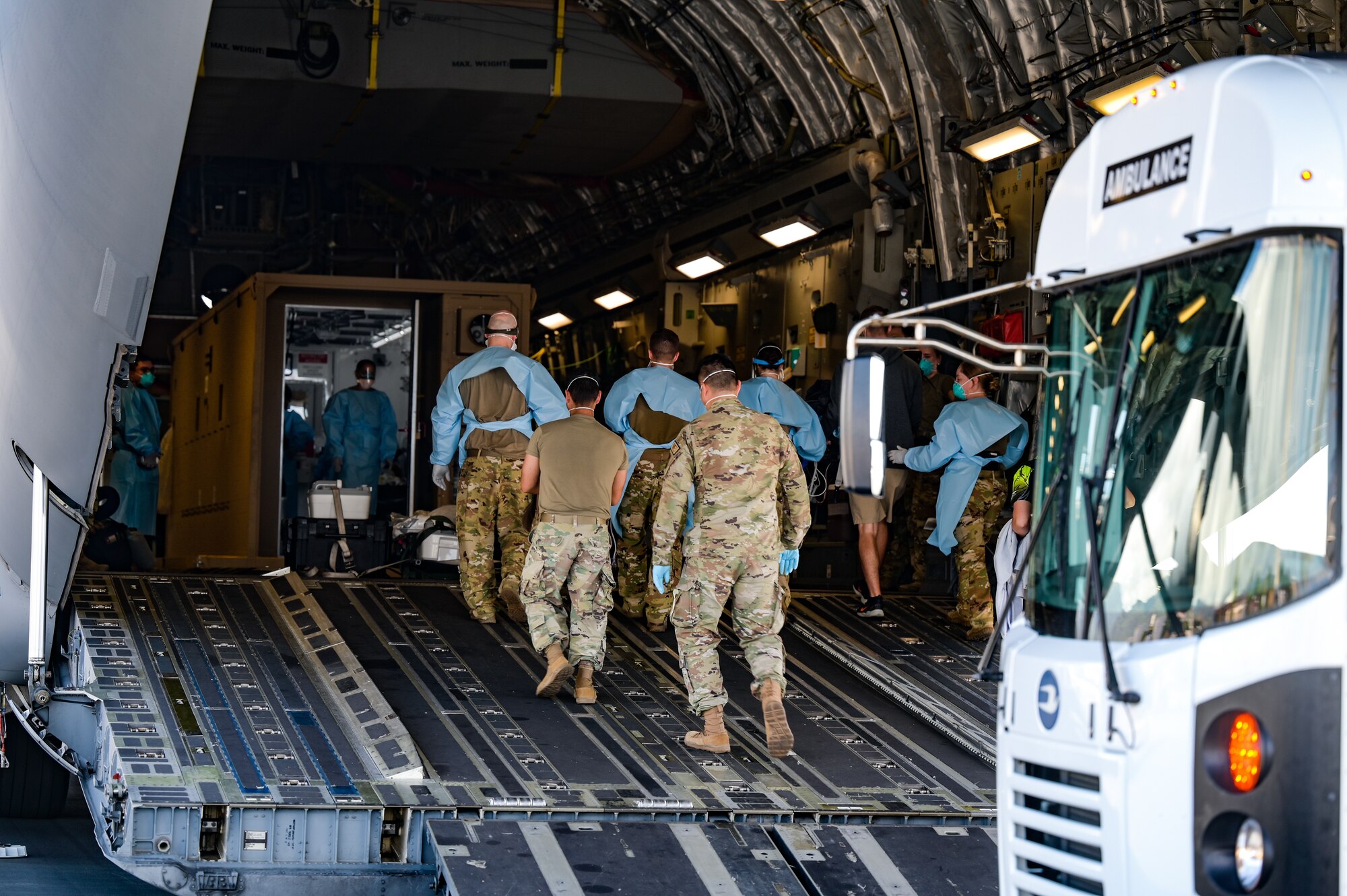 A critical air transport team from the 18th Aeromedical Evacuation Squadron and 15th Medical Group personnel escort a patient into a Negative Pressure Conex-Lite during an aircraft swap at Joint Base Pearl Harbor-Hickam, Hawaii, Sept. 21, 2022. This was the first instance within the U.S. Pacific Air Forces area of responsibility that an NCPL was moved from one aircraft to another while carrying a patient. (U.S. Air Force photo by Staff Sgt. Alan Ricker)