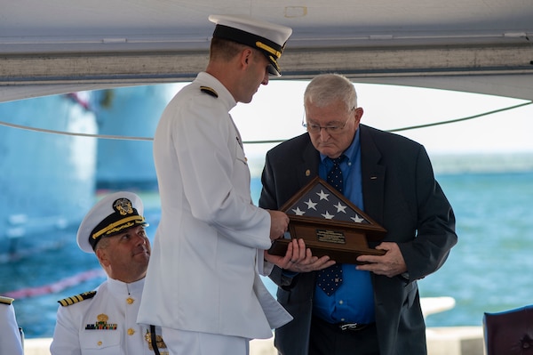 NORFOLK (Oct. 23, 2022) – Cmdr. Thad D. Tasso, commanding officer, USS Hué City (CG 66), presents Retired Capt. Tom Eubanks, Hué City’s first commanding officer, the Ensign flown Sept. 14, 2022 marking the 31st anniversary of the ship’s commissioning, during the decommissioning ceremony of the Ticonderoga-class guided-missile cruiser USS Hué City (CG 66) after 31 years of naval service. Following decommissioning, the ship is slated to be towed to

the Navy’s Inactive Ship’s facility in Philadelphia, Pa., where it will be in a Logistical Support Asset status. (U.S. Navy photo by Mass Communications Specialist 2 nd Class Darien G. Kenney)