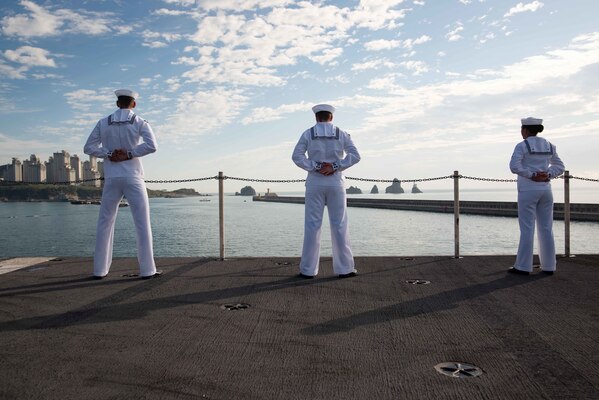 BUSAN, Republic of Korea (Sept. 23, 2022) Sailors man the rails on the flight deck of the U.S. Navy’s only forward-deployed aircraft carrier, USS Ronald Reagan (CVN 76), as the ship pulls in to Busan, Republic of Korea for a routine port visit. Ronald Reagan, the flagship of Carrier Strike Group 5, provides a combat-ready force that protects and defends the United States, and supports alliances, partnerships and collective maritime interests in the Indo-Pacific region. (U.S. Navy photo by Mass Communication Specialist 3rd Class Dallas Snider)