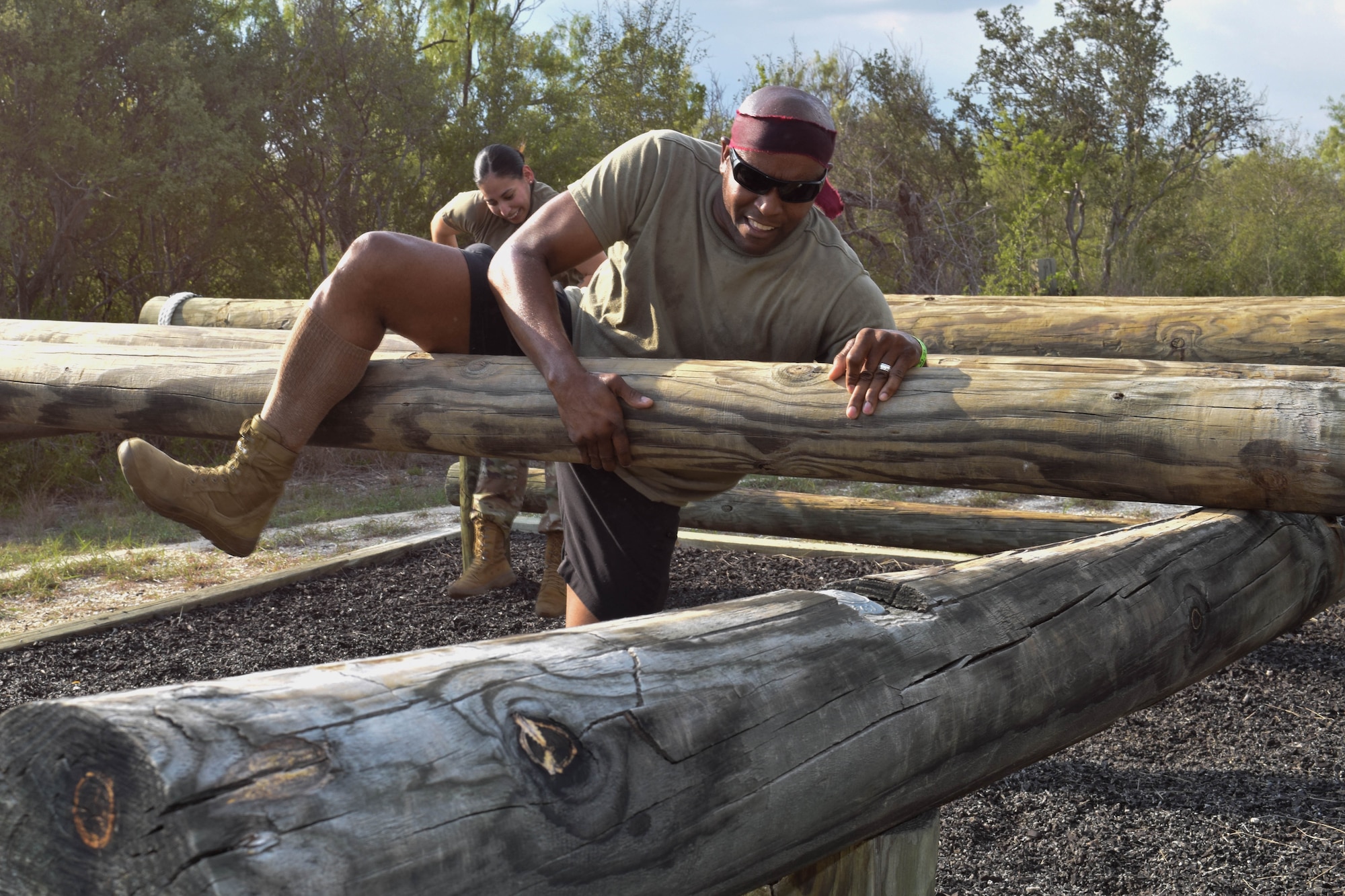 Tech. Sgt. Ira Chaney, 433rd Airlift Wing religious affairs Airman, climbs over a log in an obstacle course during a combat dining-in event at Joint Base San Antonio-Chapman Training Annex, Texas, Sept. 10, 2022. The obstacle course included low crawls, rope crawls, log jumps and wall crawls. (U.S. Air Force photo by Senior Airman Brittany Wich)