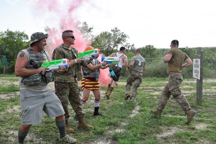 Airmen with the 433rd Airlift Wing shoot water at participants during a combat dining-in event at Joint Base San Antonio-Chapman Training Annex, Texas, Sept. 10, 2022. The event was hosted by the 433rd SFS to build camaraderie and rapport within the wing. (U.S. Air Force photo by Senior Airman Brittany Wich)