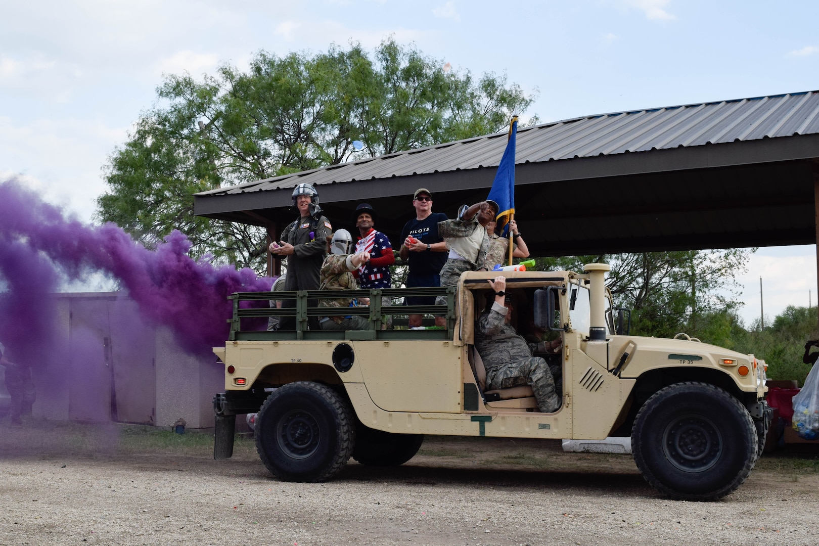 The 433rd Airlift Wing combat dining-in official party throws water balloons from the back of a Humvee at Joint Base San Antonio-Chapman Training Annex, Texas, Sept. 10, 2022. Members were encouraged to wear costumes and mix-matched uniforms during the event to boost morale. (U.S. Air Force photo by Senior Airman Brittany Wich)