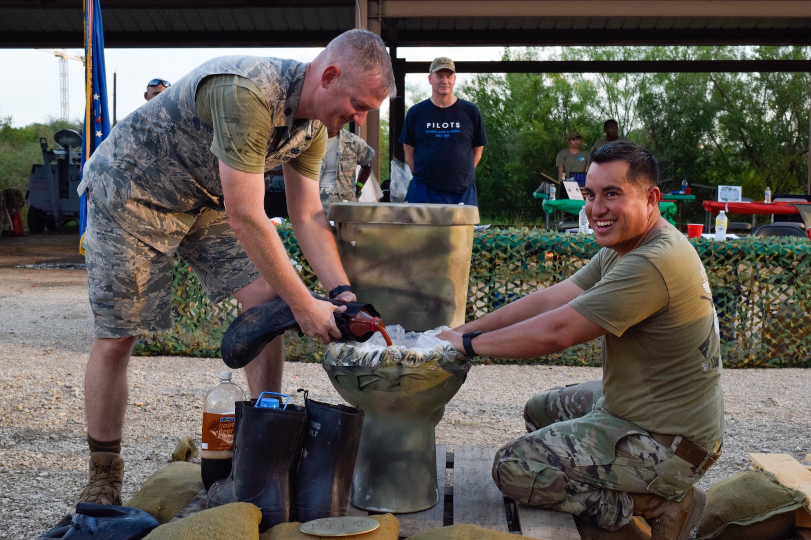Maj. Mark Howard, 433rd Security Forces Squadron commander, and Tech. Sgt. Steven Redgate, 433rd SFS defender, prepare the grog bowl during a combat dining-in event at Joint Base San Antonio-Chapman Training Annex, Texas, Sept. 10, 2022. The grog bowl is a U.S. Air Force tradition which contains a mixture of various beverages. (U.S. Air Force photo by Senior Airman Brittany Wich)