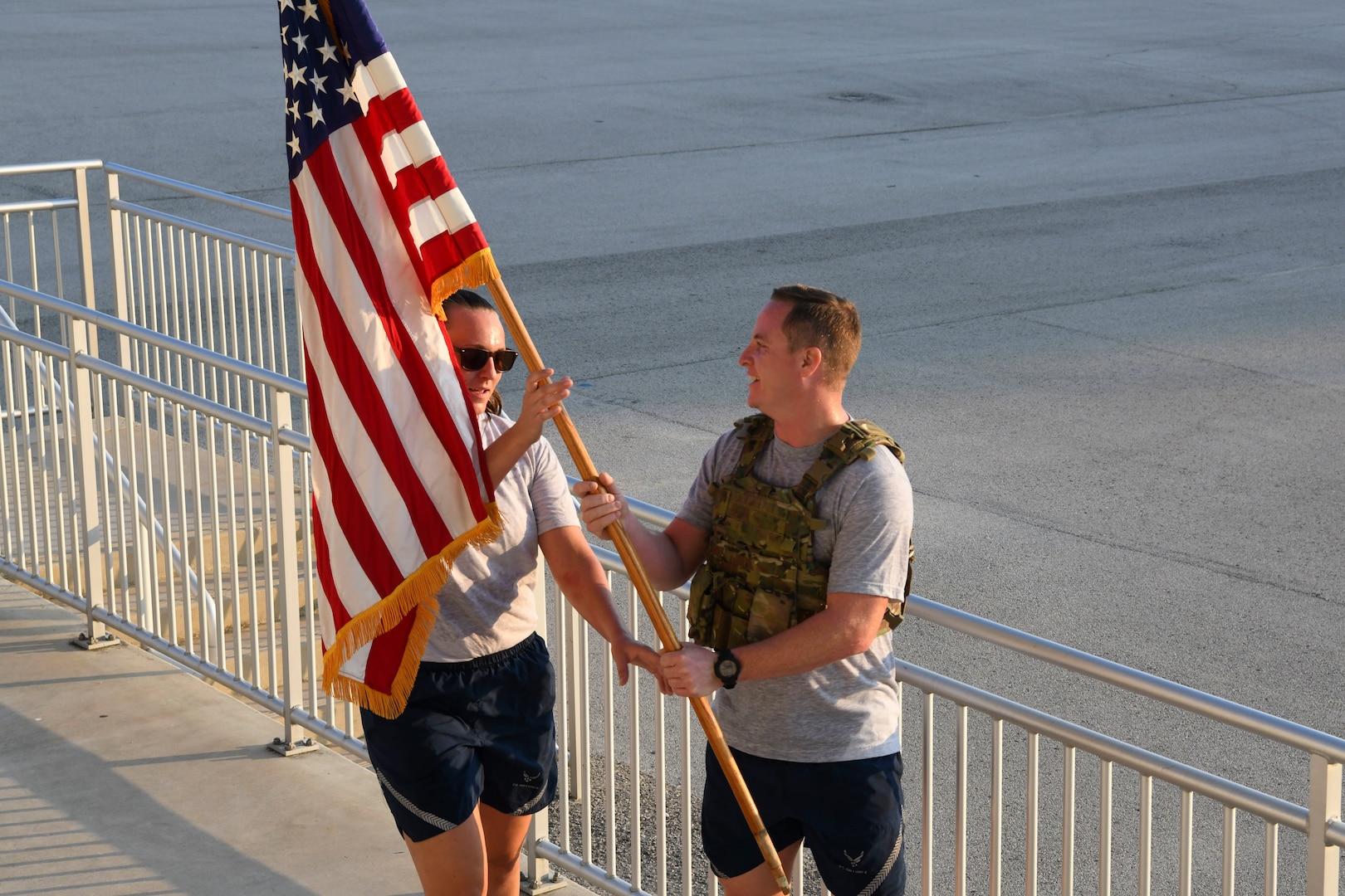 Staff Sgt. Brad Hanks, 433rd Civil Engineer Squadron explosive ordnance disposal bomb technician, passes the guidon to Tech. Sgt. Rachel Kane, 433rd CES emergency management noncommissioned officer in charge, during the 9/11 memorial stair climb at Joint Base San Antonio-Lackland, Texas, Sept.11, 2022. The 433rd CES performs a stair climb every year to commemorate the 110 flights of stairs first responders had to climb inside the World Trade Center on Sept. 11, 2001. (U.S. Air Force photo by Staff Sgt. Adriana Barrientos)