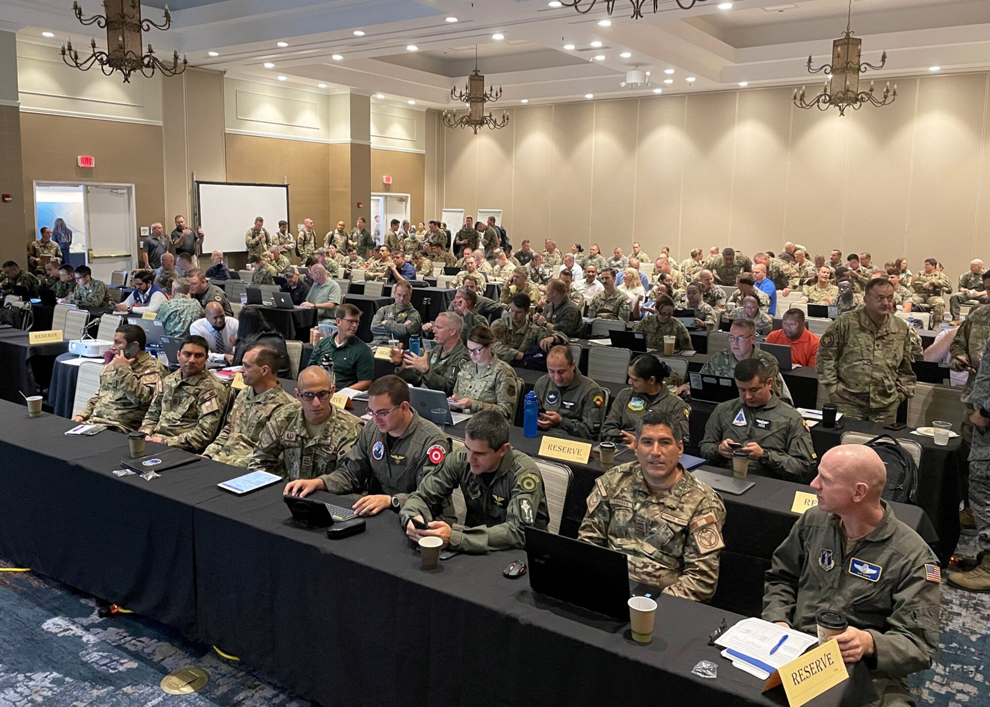 Photo of people sitting at rows of tables with computers