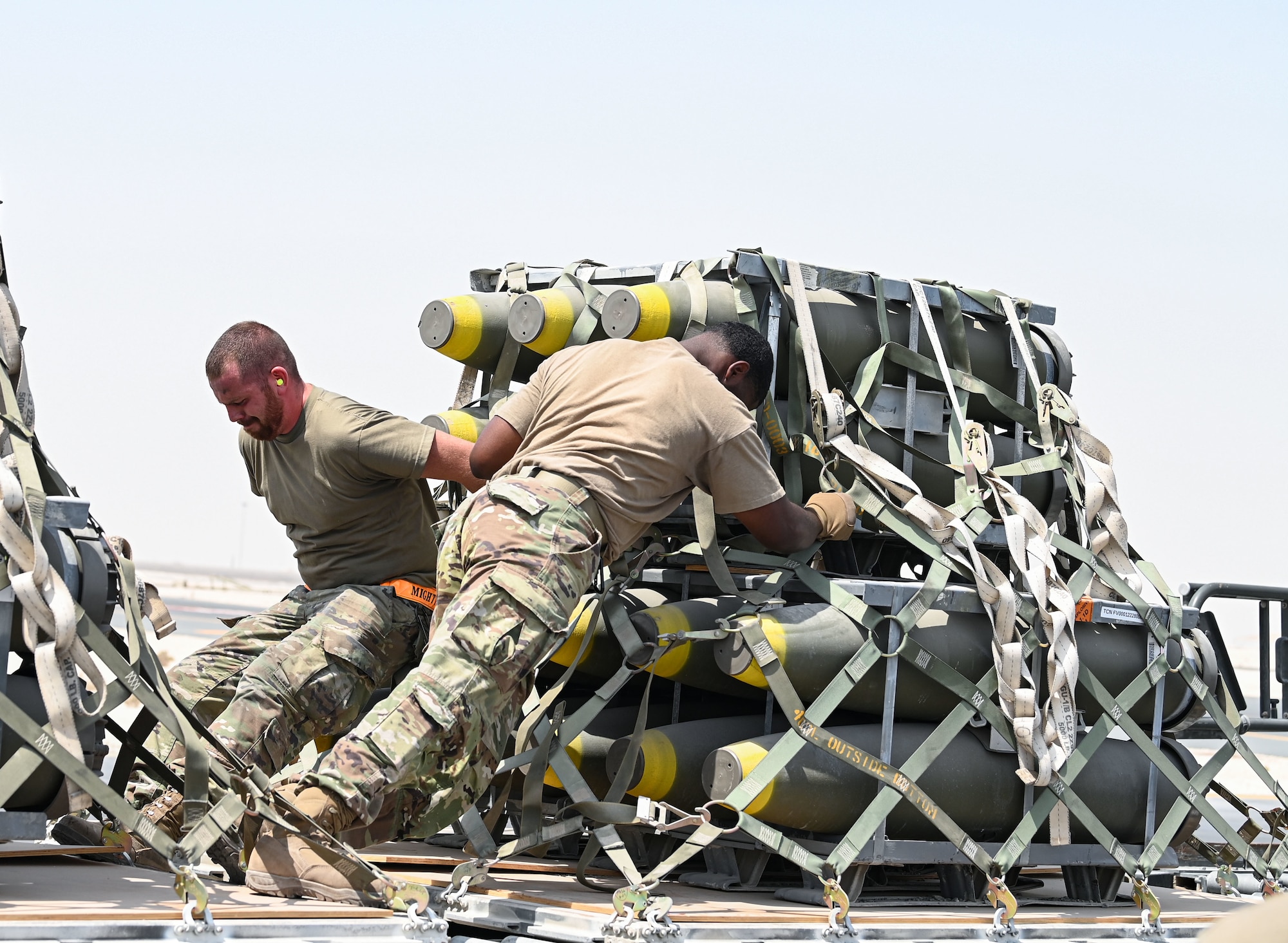 Airmen from 379th Expeditionary Readiness Squadron and 8th Expeditionary Air Mobility Squadron move a pallet of munitions onto a K-loader Sept. 20, 2022 at Al Udeid Air Base, Qatar.  The 379th ERLS ground transport team moved munitions from the munitions storage area to a staging area where they were later loaded onto a C-17 Globemaster III aircraft. (U.S. Air National Guard photo by Master Sgt. Michael J. Kelly)