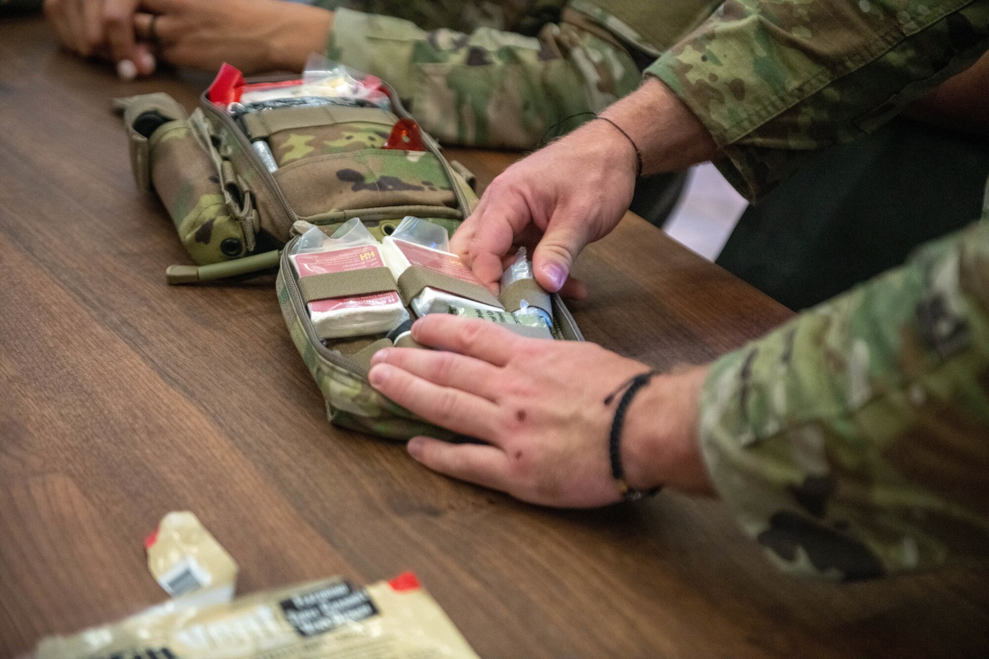 U.S. Air Force Capt. Daniel Porter, a clinical nurse with the 379th Expeditionary Operational Medical Readiness Squadron, explains parts of an Individual First Aid Kit during a training exercise at Al Udeid Air Base, Qatar, Sept. 23, 2022. The IFAK contains a tourniquet, shears, and other medical equipment to rapidly treat injuries. (U.S. Air National Guard photo by Airman 1st Class Constantine Bambakidis)