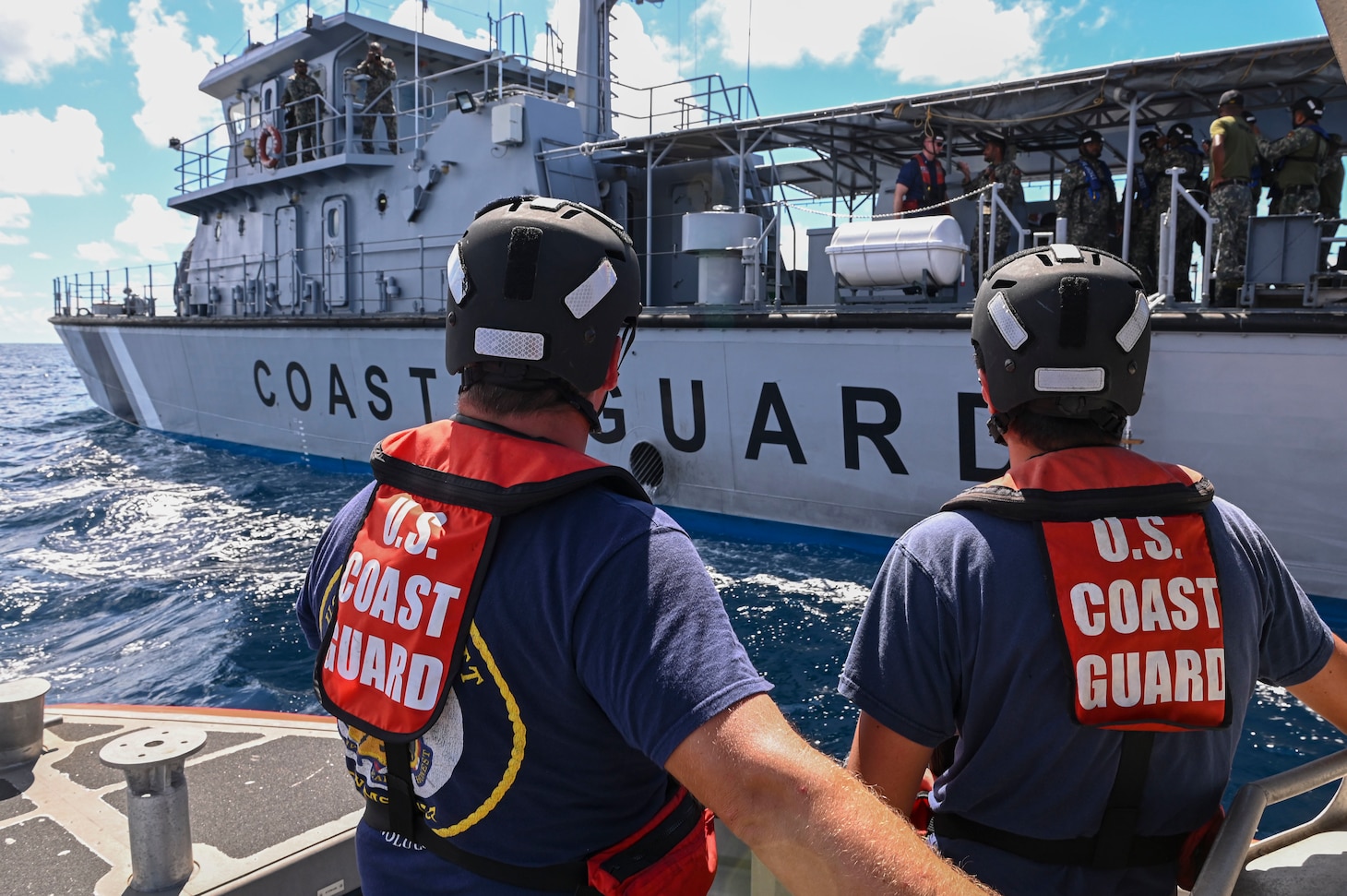 Crewmembers from U.S. Coast Guard Cutter Midgett (WMSL 757) stand ready to receive passengers from the Maldivian Coast Guard ship Ghazee during a joint exercise held in the waters east of the Maldives, Sept. 22, 2022. These professional exchanges are designed to share expertise and best practices in completing missions. (U.S. Coast Guard photo by Petty Officer Steve Strohmaier)