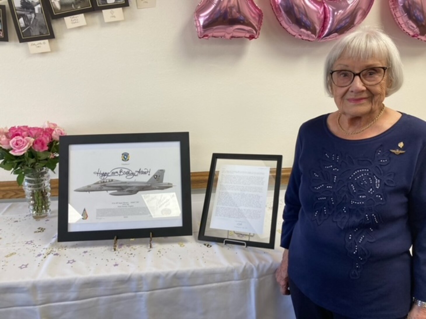 Alice Starnes poses for a photo with mementos presented to her during a celebration of her 100th birthday.