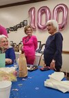 Alice Starnes (right) chats with family members during a celebration of her 100th birthday.