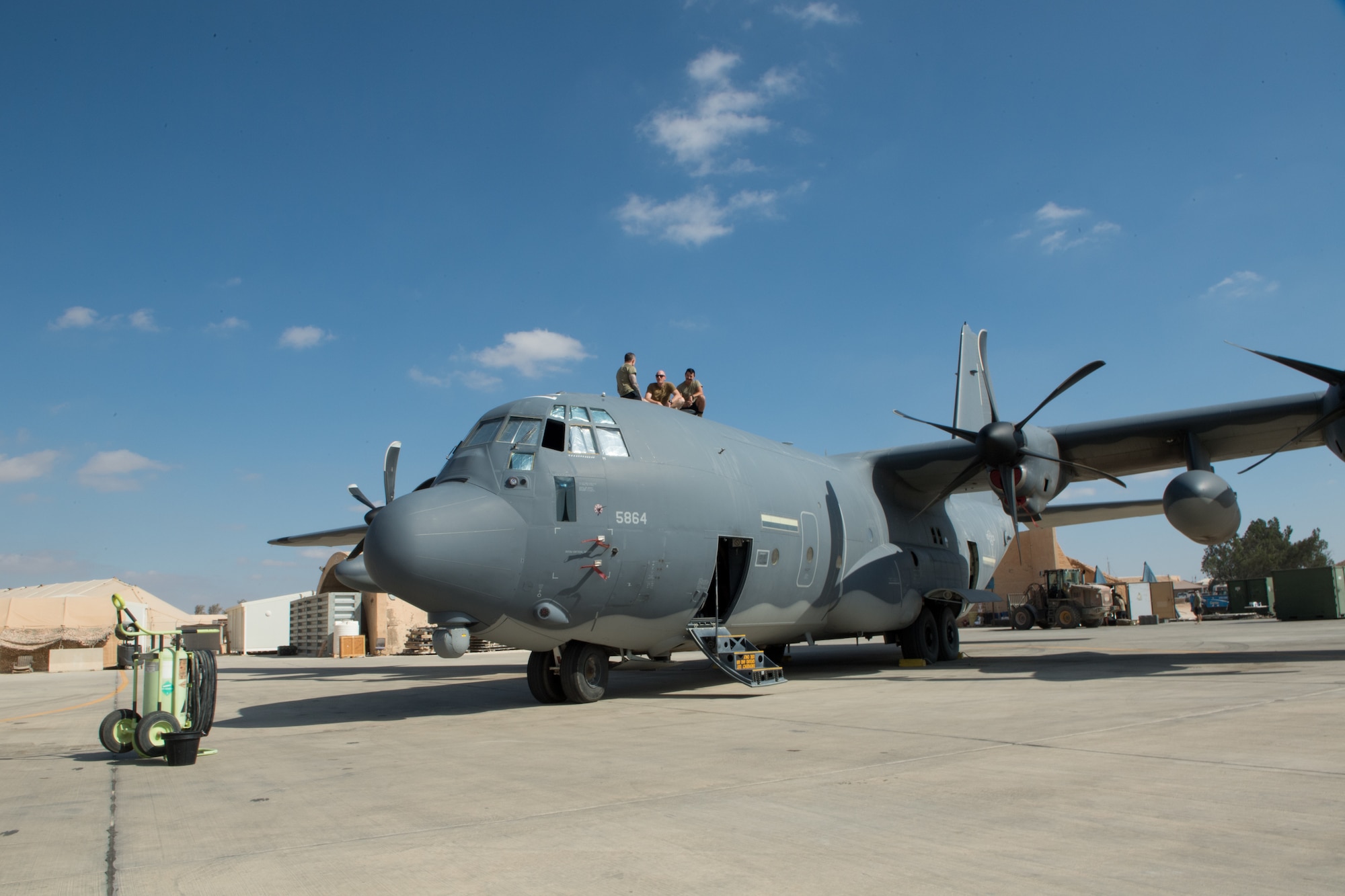 U.S. Air Force Col. Jason Houston and Chief Master Sgt. Kevin Eberlin, 332d Air Expeditionary Wing leadership, sit on top of C-130J Super Hercules aircraft with Tech. Sgt. Michael Sanchez, a Crew Chief with the 801st Expeditionary Maintenance Squadron, as part of the “Red Tail Connection” program at an undisclosed location in Southwest Asia, September 21, 2022. These immersion visits provide greater insight into the unique skillsets every Airman brings to the 332d AEW Red Tail team. (U.S. Air Force photo by Tech. Sgt. Richard Mekkri)