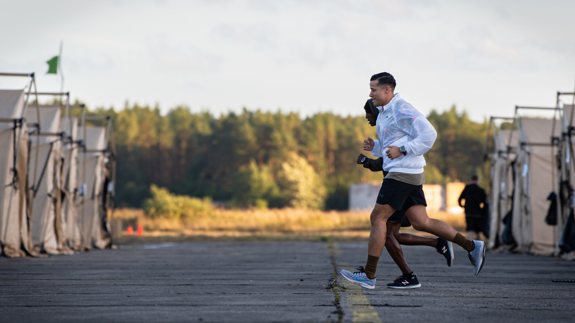 U.S. Air Force Master Sgt. Hector Gonzalez, front, 435th Contingency Response Squadron aircraft maintenance flight assistant chief, and Staff Sgt. Habtamu Simegnew, back, 435th CRS engineering craftsman, run for personal physical training during exercise Agile Wolf 22 at Koszalin, Poland, Sept. 15, 2022.  Contingency Response Squadron. (U.S. Air Force photo by Airman 1st Class Jared Lovett)