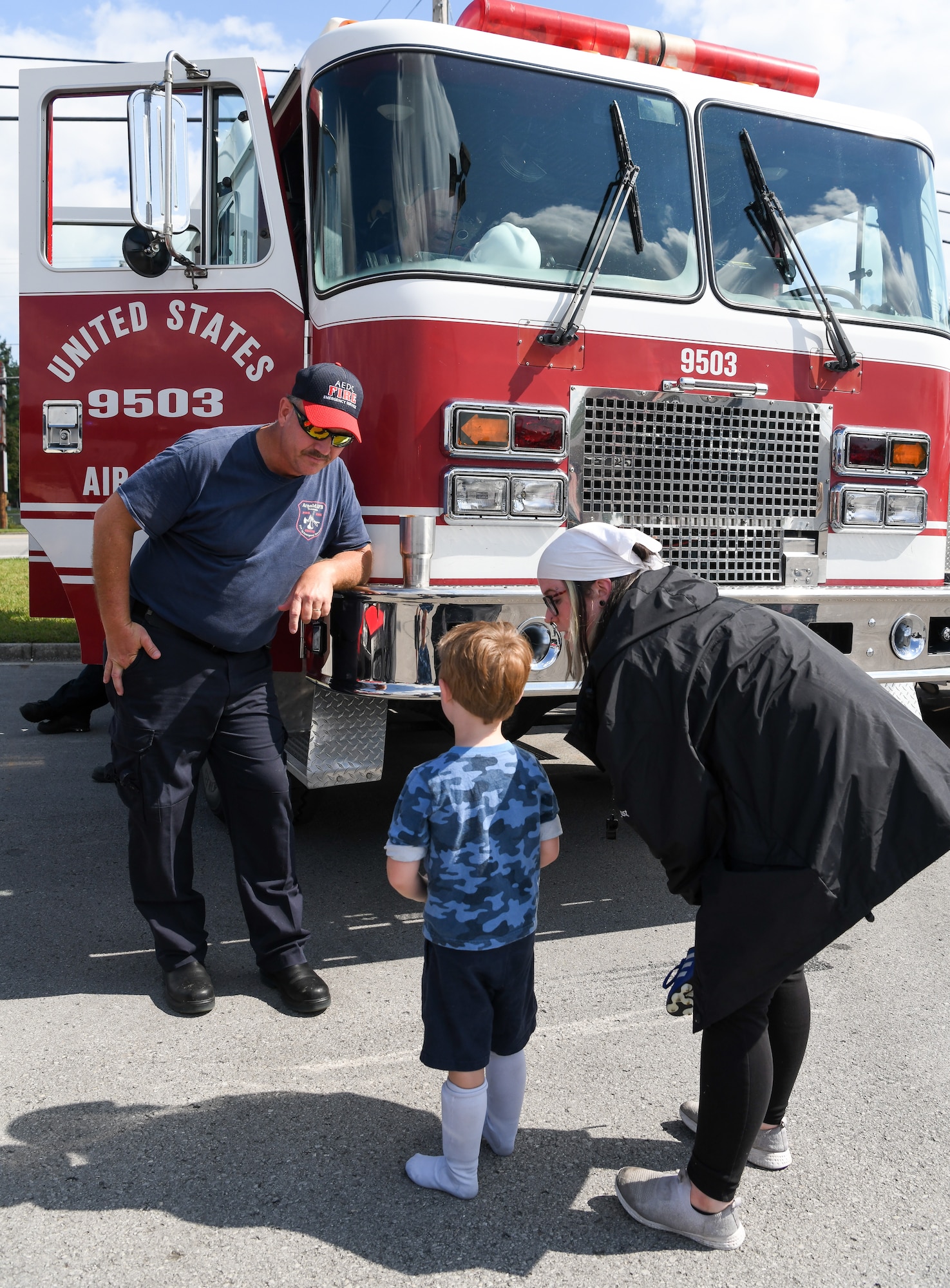 A firefighter speaks with a young boy and the boy's mother
