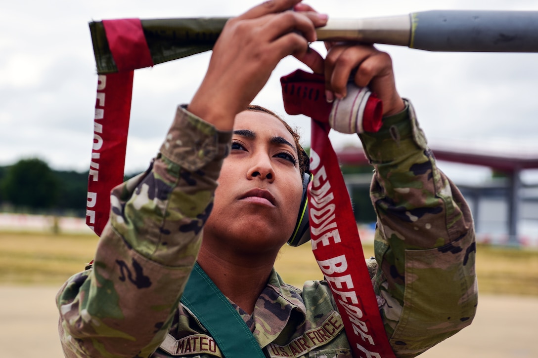 A uniformed service member covers a plane part.