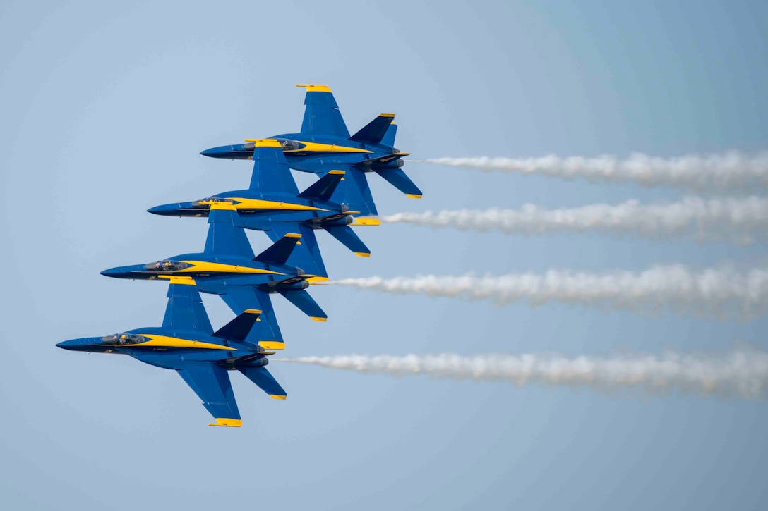 Four military jets fly close together.