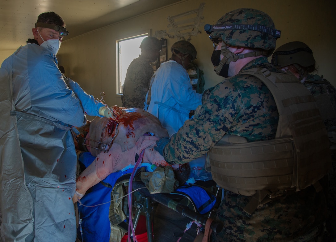 U.S. Sailors with 1st Medical Battalion, 1st Marine Logistics Group, I Marine Expeditionary Force, perform surgery on a simulated casualty during a field training exercise at Camp Pendleton, California, Jan. 24, 2022.