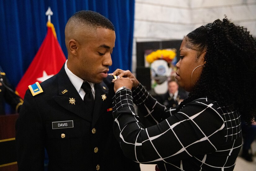 Army officer candidate Isiah Davis is pinned second lieutenant by his mother during the officer commissioning ceremony at the Kentucky State Capitol rotunda in Frankfort, Ky. on Sept. 24, 2022. Davis and six other officer candidates were commissioned as officers in the Kentucky National Guard by friends and family. (U.S. Army photo by Andy Dickson)