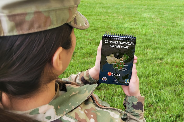 Airman holding Expeditionary Culture Field Guide
