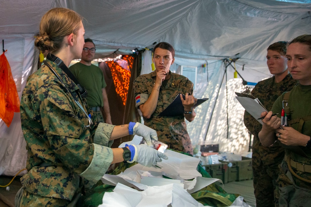 U.S. Navy Hospital Corpsman Irene Avila with 1st Medical Battalion, 1st Marine Logistics Group, I Marine Expeditionary Force, checks the breathing of a simulated patient during a Marine Corps Combat Readiness Evaluation exercise on Camp Pendleton, California, April 9, 2022.