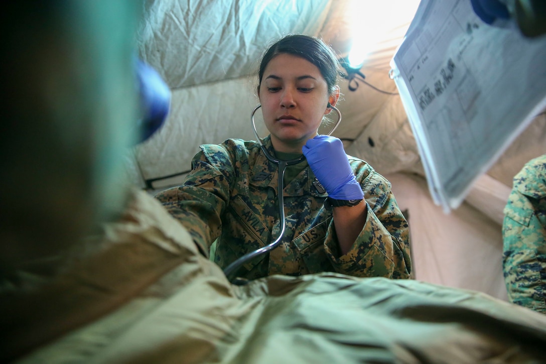 U.S. Navy Hospital Corpsman Irene Avila with 1st Medical Battalion, 1st Marine Logistics Group, I Marine Expeditionary Force, checks the breathing of a simulated patient during a Marine Corps Combat Readiness Evaluation exercise on Camp Pendleton, California, April 9, 2022.