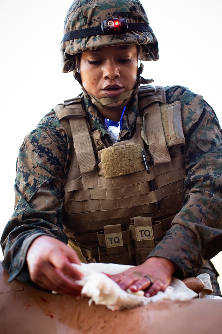 U.S. Navy Hospital Corpsman 2nd Class Kenitha Harris with 1st Medical Battalion, 1st Marine Logistics Group, I Marine Expeditionary Force, applies an H-Bandage during a Tactical Combat Casualty Care (TCCC) course held by the Combat Skills Training (CSTS) School on Camp Pendleton, California, Dec. 17, 2021.