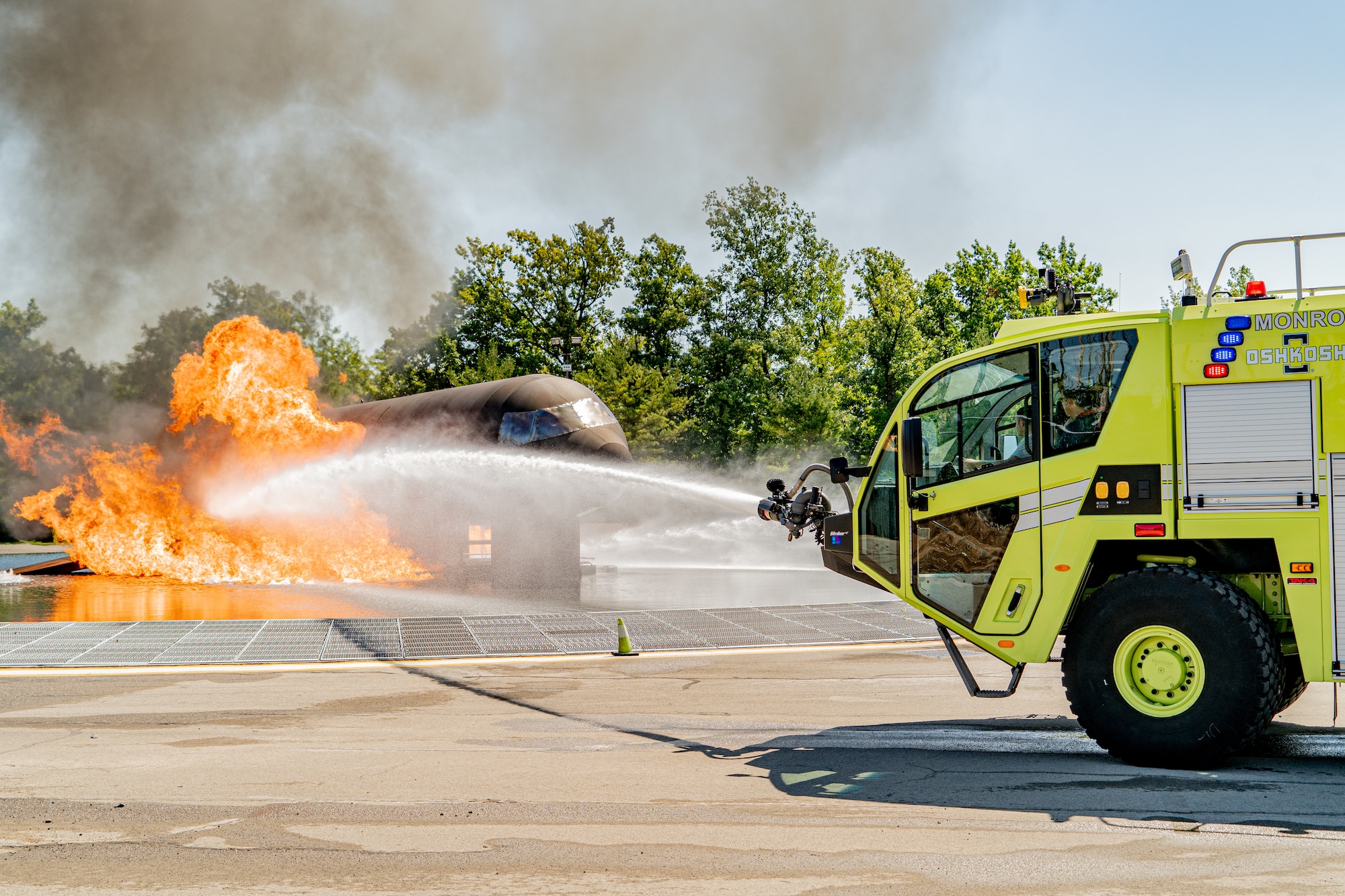 Firefighters with the 914th Fire Emergency Services control a firetrucks water cannon to put out a simulated aircraft's fire during training.