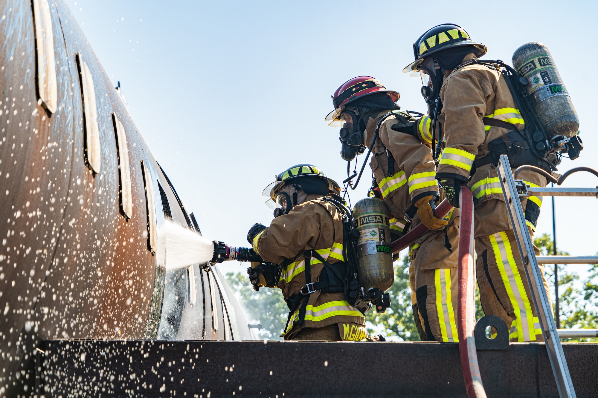 Firefighters with the 914th Fire Emergency Services stand on top of a simulated aircrafts wing to put out an internal aircraft structure fire.