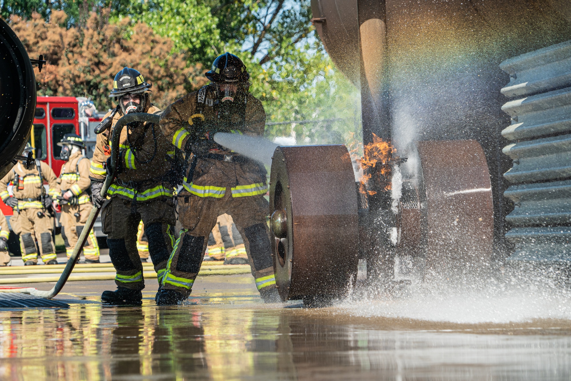 Firefighters with the 914th Fire Emergency Services extinguish an aircraft brake fire while conducting fire suppression training.
