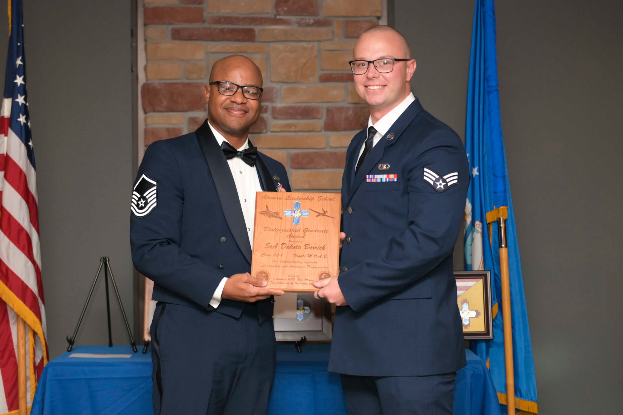 U.S. Air Force Senior Airman Dakota Barrick, right, accepts the Distinguished Graduate Award from Holloman Top III representative Master Sgt. Troy Campbell during an Airman Leadership School graduation at Holloman Air Force Base, New Mexico, Sept. 22, 2022. The distinguished graduate award is presented to the top ten-percent of graduates for their performance in academic evaluations and demonstration of leadership. (U.S. Air Force photo by Tech. Sgt. Victor J. Caputo)
