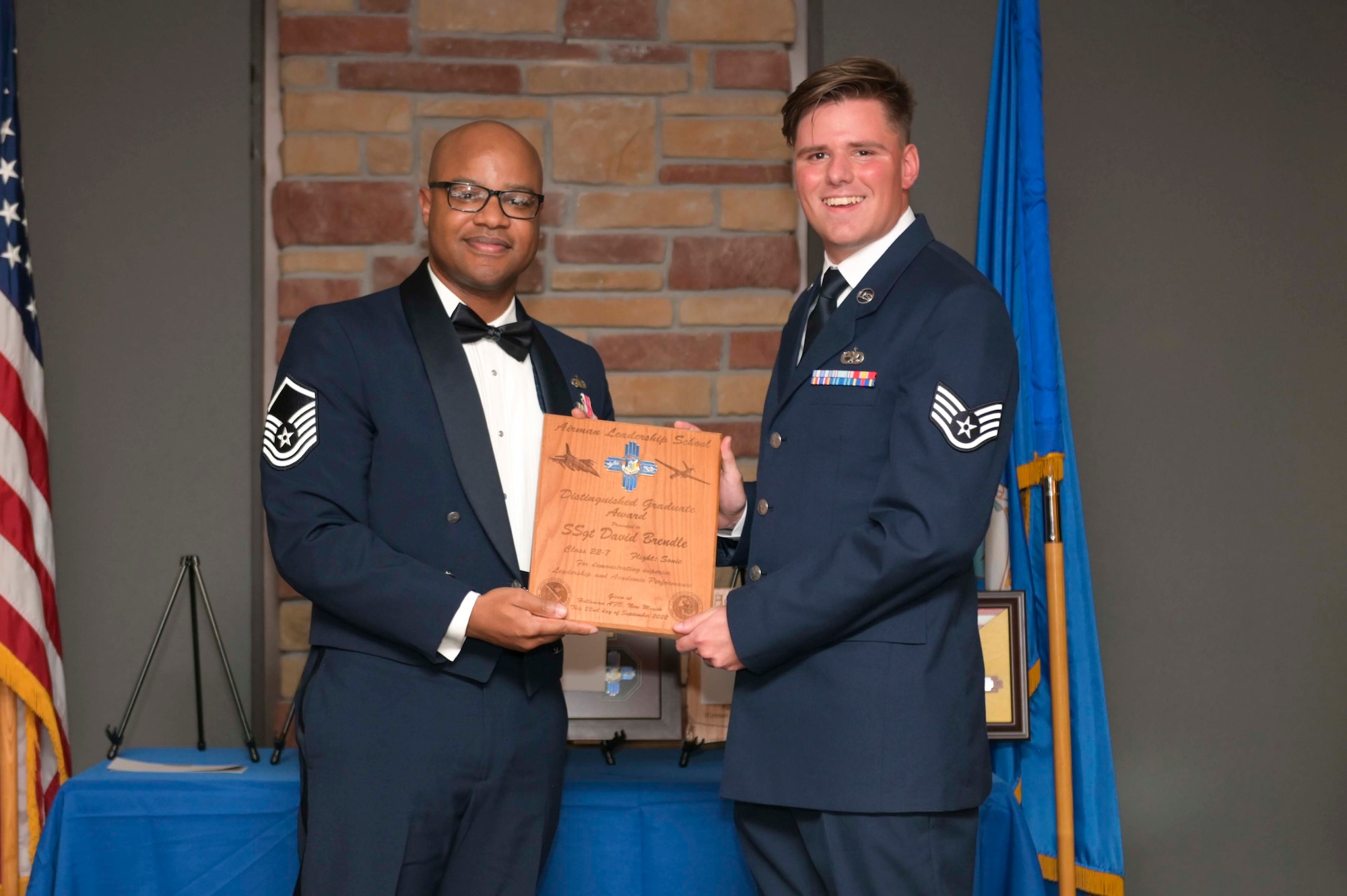U.S. Air Force Staff Sgt. David Brendle, right, accepts the Distinguished Graduate Award from Holloman Top III representative Master Sgt. Troy Campbell during an Airman Leadership School graduation at Holloman Air Force Base, New Mexico, Sept. 22, 2022. The distinguished graduate award is presented to the top ten-percent of graduates for their performance in academic evaluations and demonstration of leadership. (U.S. Air Force photo by Tech. Sgt. Victor J. Caputo)