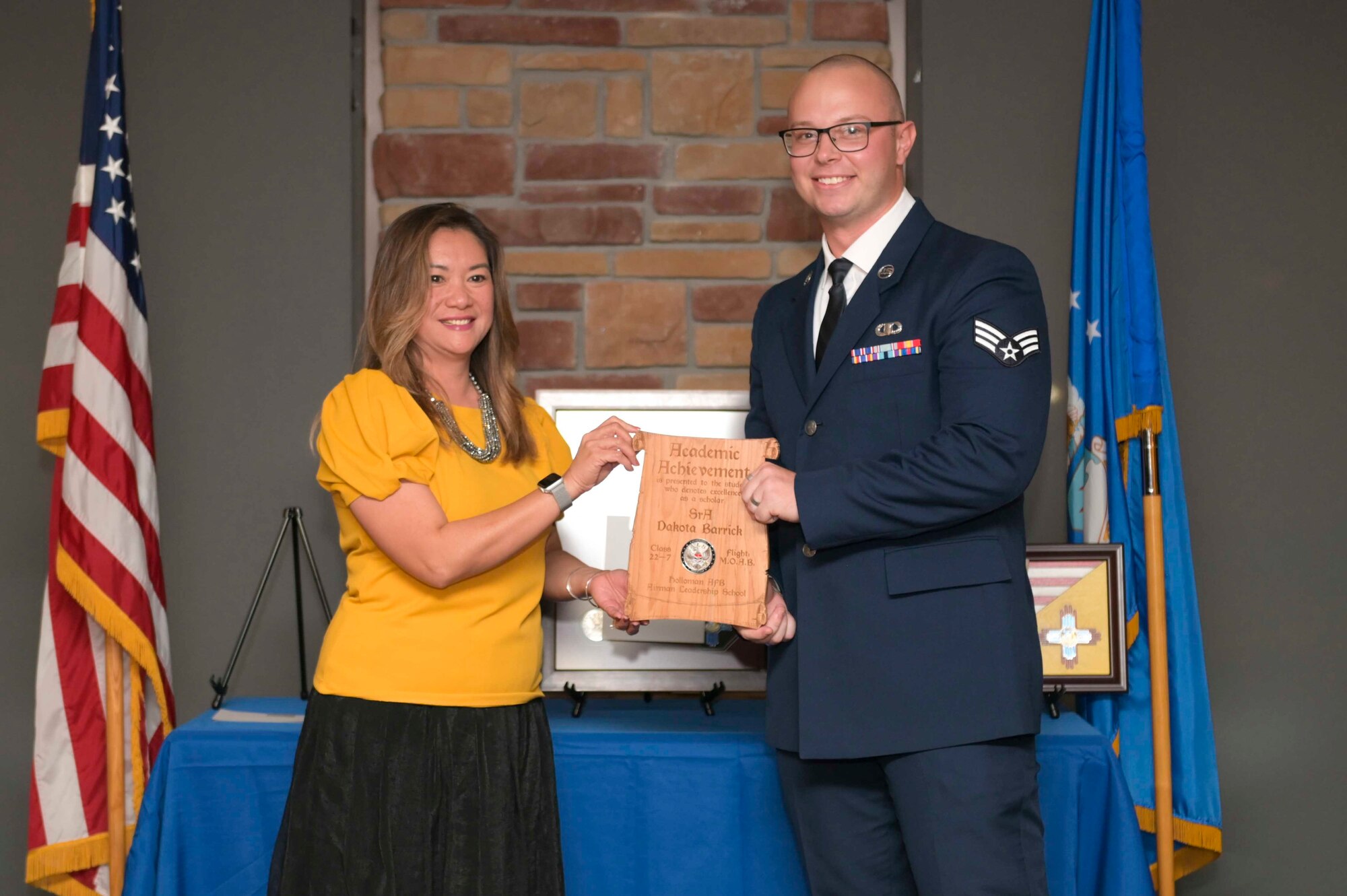 U.S. Air Force Senior Airman Dakota Barrick, right, accepts the Academic Achievement Award from Laney Cooper, Otero Federal Credit Union representative, during an Airman Leadership School graduation at Holloman Air Force Base, New Mexico, Sept. 22, 2022. The academic award is presented to the student with the highest overall average on all academic evaluations. (U.S. Air Force photo by Tech. Sgt. Victor J. Caputo)