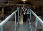 People in reflective gear and uniforms with radios stand on a observation catwalk at the DSCC Shoot House in Building  18.