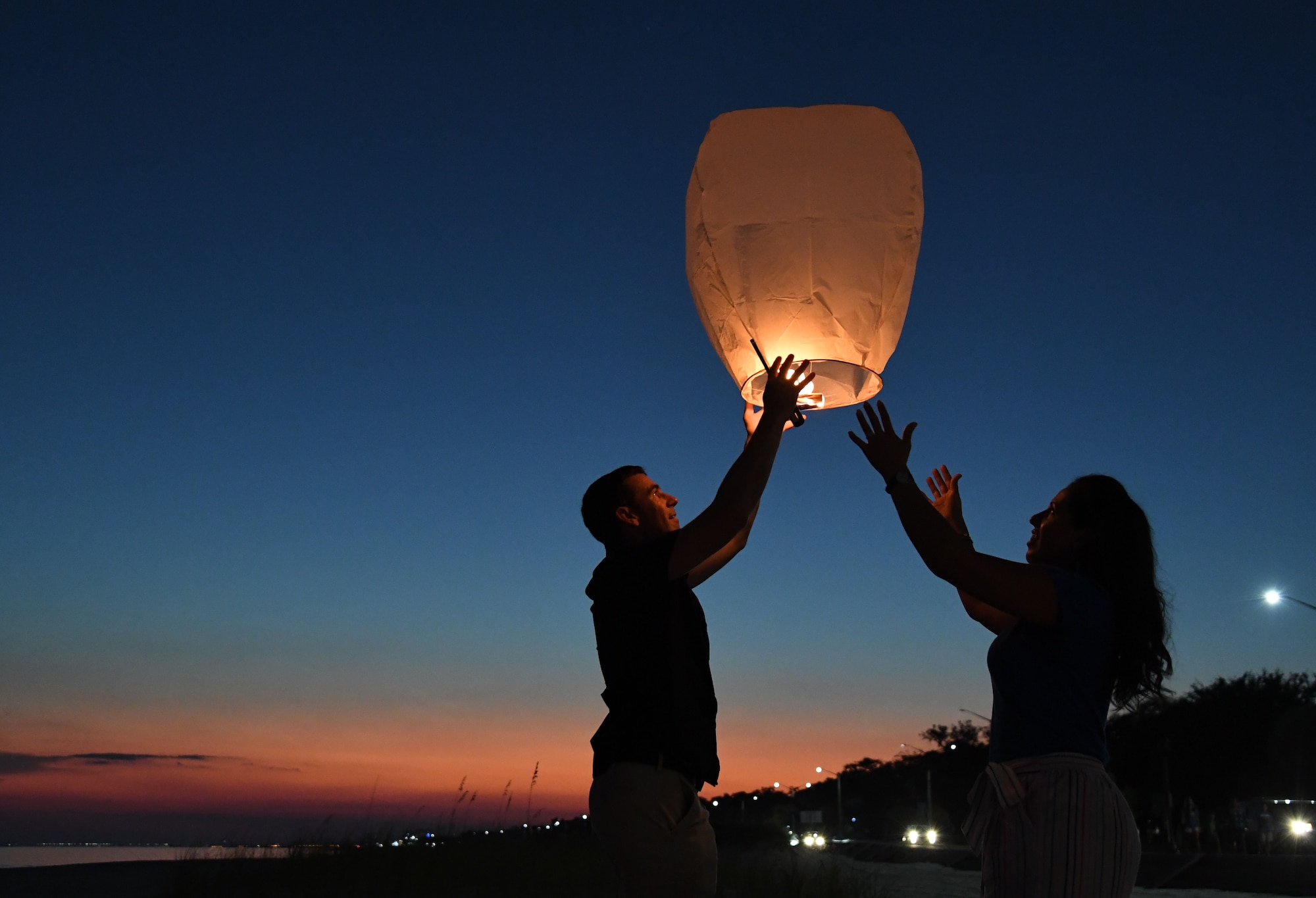 U.S. Air Force Col. Jason Allen, 81st Training Wing vice commander, and his wife, Mayra, release a lantern during the Gold Star Families Sky Lantern Release on the Biloxi Beach, Mississippi, Sept. 23, 2022. The event, hosted by Keesler Air Force Base, included eco-friendly sky lanterns released in honor of fallen heroes. (U.S. Air Force photo by Kemberly Groue)