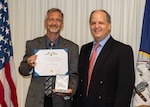 (right) Naval Surface Warfare Center Panama City Division (NSWC PCD) Science and Technology Department Head Dr. Keith Aliberti presents John Holloway, NSWC PCD project manager, with the U.S. Navy Civilian Service Commendation Medal, Sept. 6.  He is a subject matter expert in Airborne Mine Countermeasures (AMCM) and has continuously supported the warfighter through innovation and dedication to the field of AMCM. (U.S. Navy photo by Ronnie Newsome)