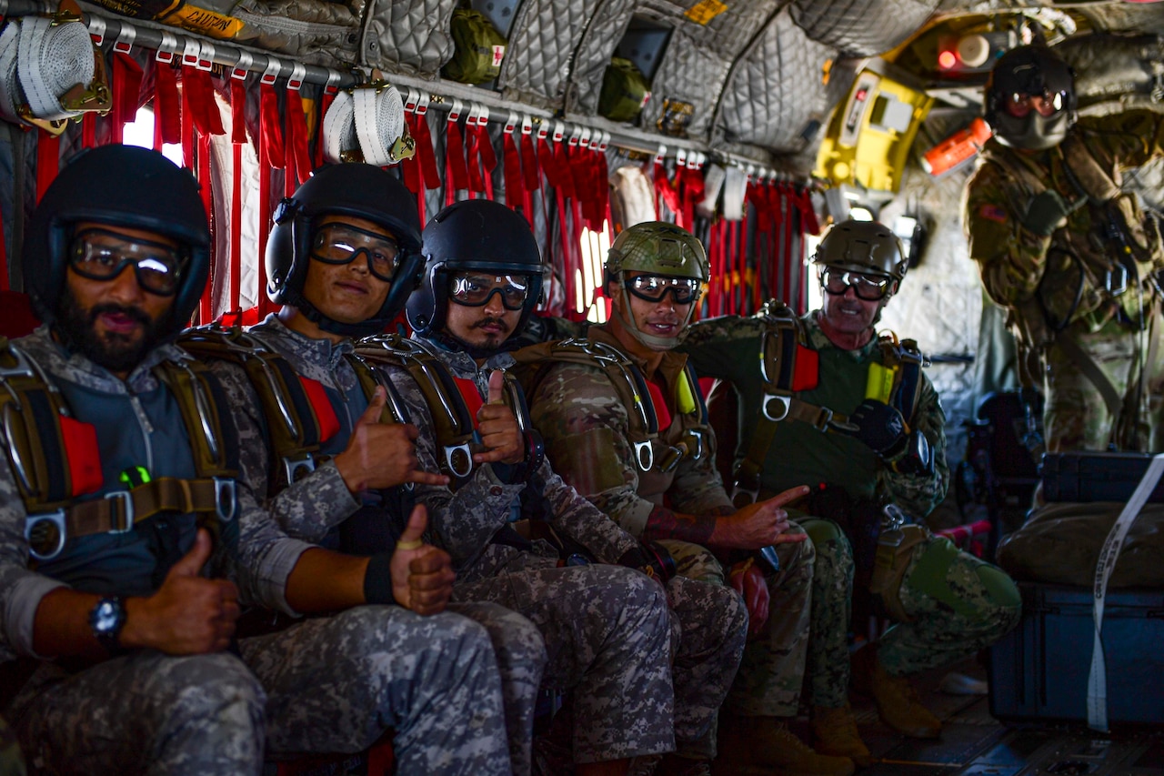 Service members pose for photo aboard helicopter.