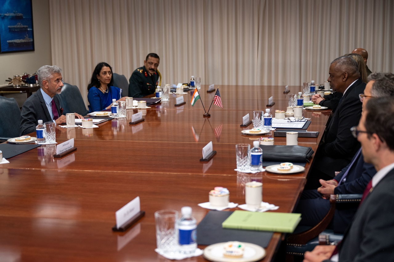 People are engaged in conversation around a conference table.