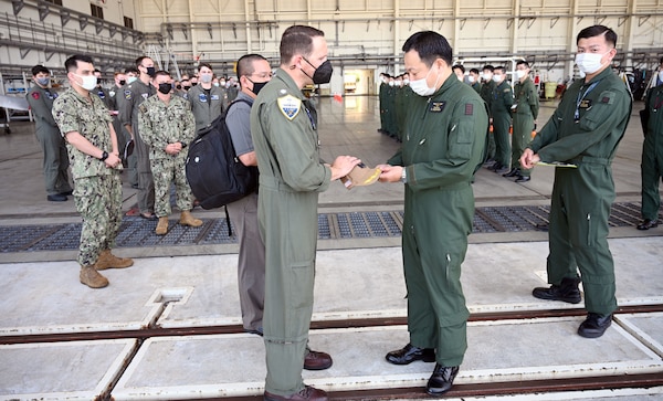 KADENA AIR BASE, Japan (Sept. 21, 2022) – Cmdr. Nicholas Bullard, commanding officer of Fleet Air Reconnaissance Squadron (VQ) 1 presents a gift to Capt. Sugahara Katsunori, commanding officer of Japan Maritime Self-Defense Force Air Reconnaissance Squadron (VQ) 81, during Raijin 22-2, an annual unit exchange. Based out of Whidbey Island, Washington, the VQ-1 “World Watchers” are currently operating from Kadena Air Base in Okinawa, Japan. The squadron conducts naval operations as part of a rotational deployment to the U.S. 7th Fleet area of operations. (U.S. Navy photo by Mass Communication Specialist First Class Glenn Slaughter)