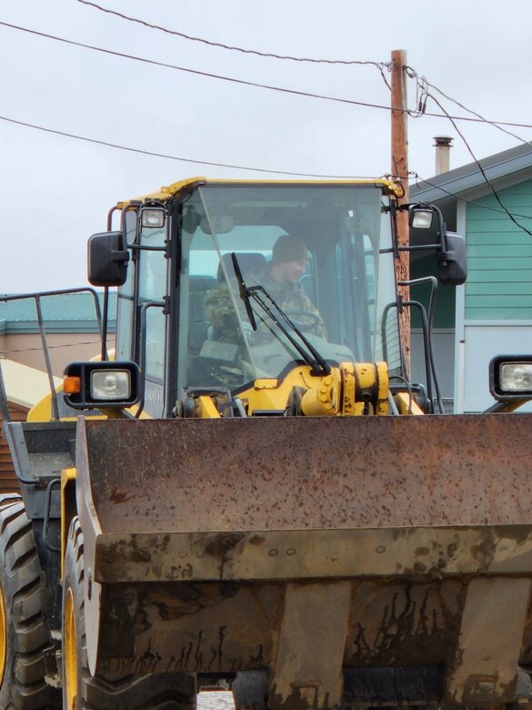A member of the Alaska Organized Militia operates a front-end loader tractor to clear storm debri in Golovin, Alaska as part of Operation Merbok Response Sept. 26, 2022. More than members of the Alaska Organized Militia, which includes members of the Alaska National Guard, Alaska State Defense Force and Alaska Naval Militia, were activated following a disaster declaration issued Sept. 17 after the remnants of Typhoon Merbok caused dramatic flooding across more than 1,000 miles of Alaskan coastline. (Alaska National Guard Courtesy photo)