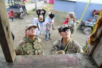 Alaska Army National Guard Spc. Tristan John, right, an infantryman with 1st Battalion, 297th Infantry Regiment from  Kwigillingok, and Alaska Air National Guard Staff Sgt. Kua Xiong, a services technician with the 176th Force Support Squadron from Anchorage, discuss options as they repair a damaged porch as part of Operation Merbok Response in Toksook Bay, Alaska, Sept. 24, 2022. More than 130 members of the Alaska Organized Militia, which includes members of the Alaska National Guard, Alaska State Defense Force and Alaska Naval Militia, were activated following a disaster declaration issued Sept. 17 after the remnants of Typhoon Merbok caused dramatic flooding across more than 1,000 miles of Alaskan coastline. (Alaska National Guard photo by 1st Lt. Balinda O'Neal)