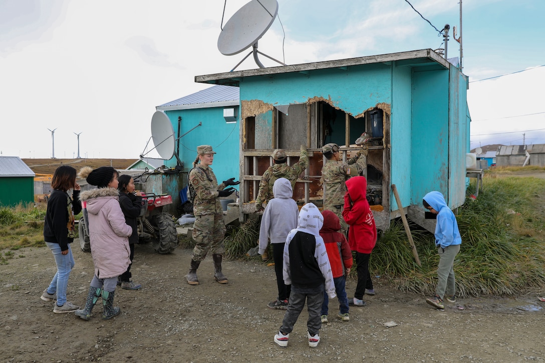 Alaska Air National Guard Senior Airman Emily Batchelor, a public affairs specialist with the 176th Wing from Eagle River, explains how service members from Joint Task Force – Bethel are going to repair a damaged porched as part of Operation Merbok Response in Toksook Bay, Alaska, Sept. 24, 2022. More than 130 members of the Alaska Organized Militia, which includes members of the Alaska National Guard, Alaska State Defense Force and Alaska Naval Militia, were activated following a disaster declaration issued Sept. 17 after the remnants of Typhoon Merbok caused dramatic flooding across more than 1,000 miles of Alaskan coastline. (Alaska National Guard photo by 1st Lt. Balinda O'Neal)