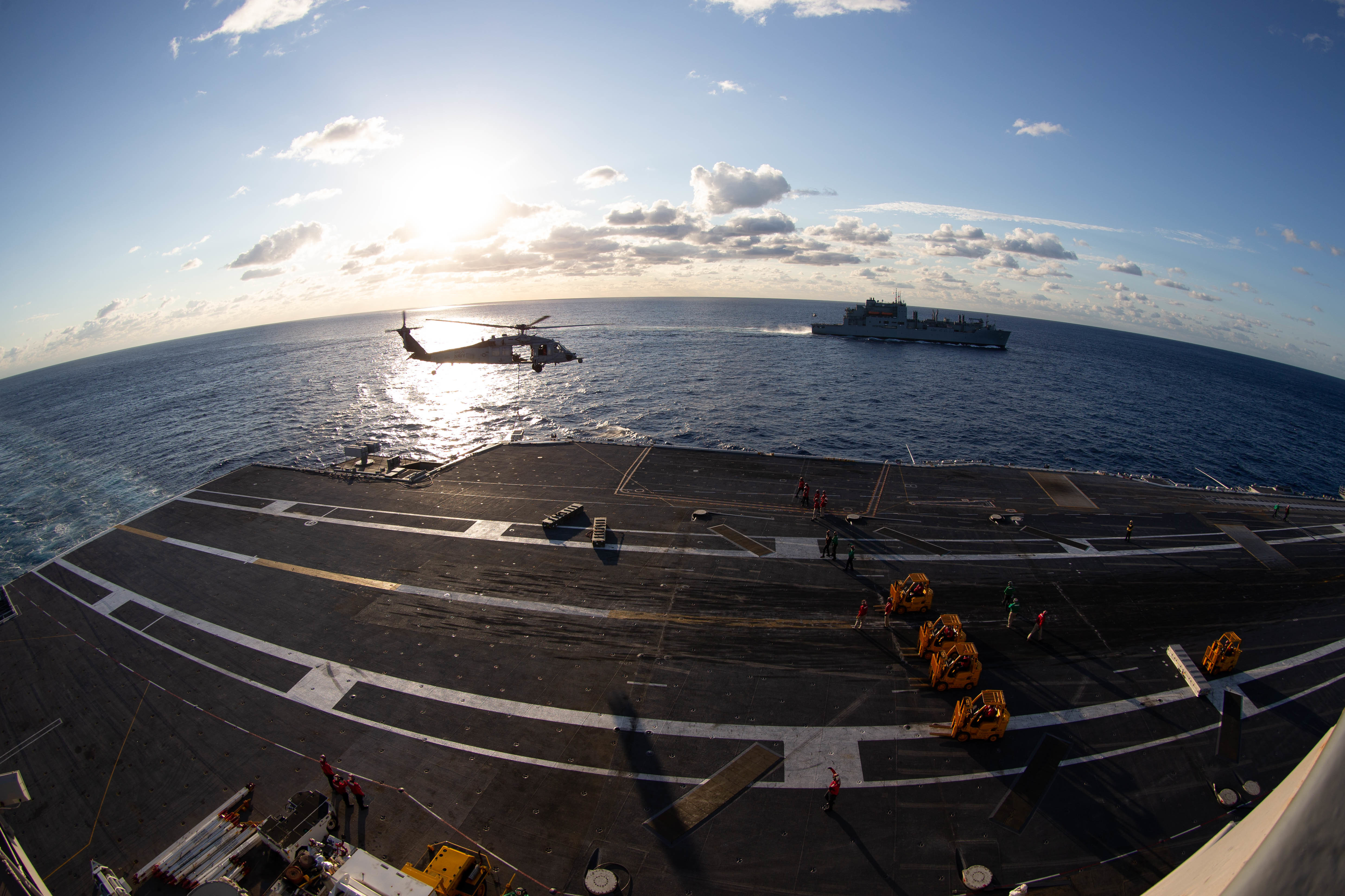 An MH-60S Nighthawk transports ammunition to the aircraft carrier USS Gerald R. Ford (CVN 78) during an ammunition onload with USNS Medgar Evers (T-AKE 13) on the flight deck, Sept. 25, 2022.
