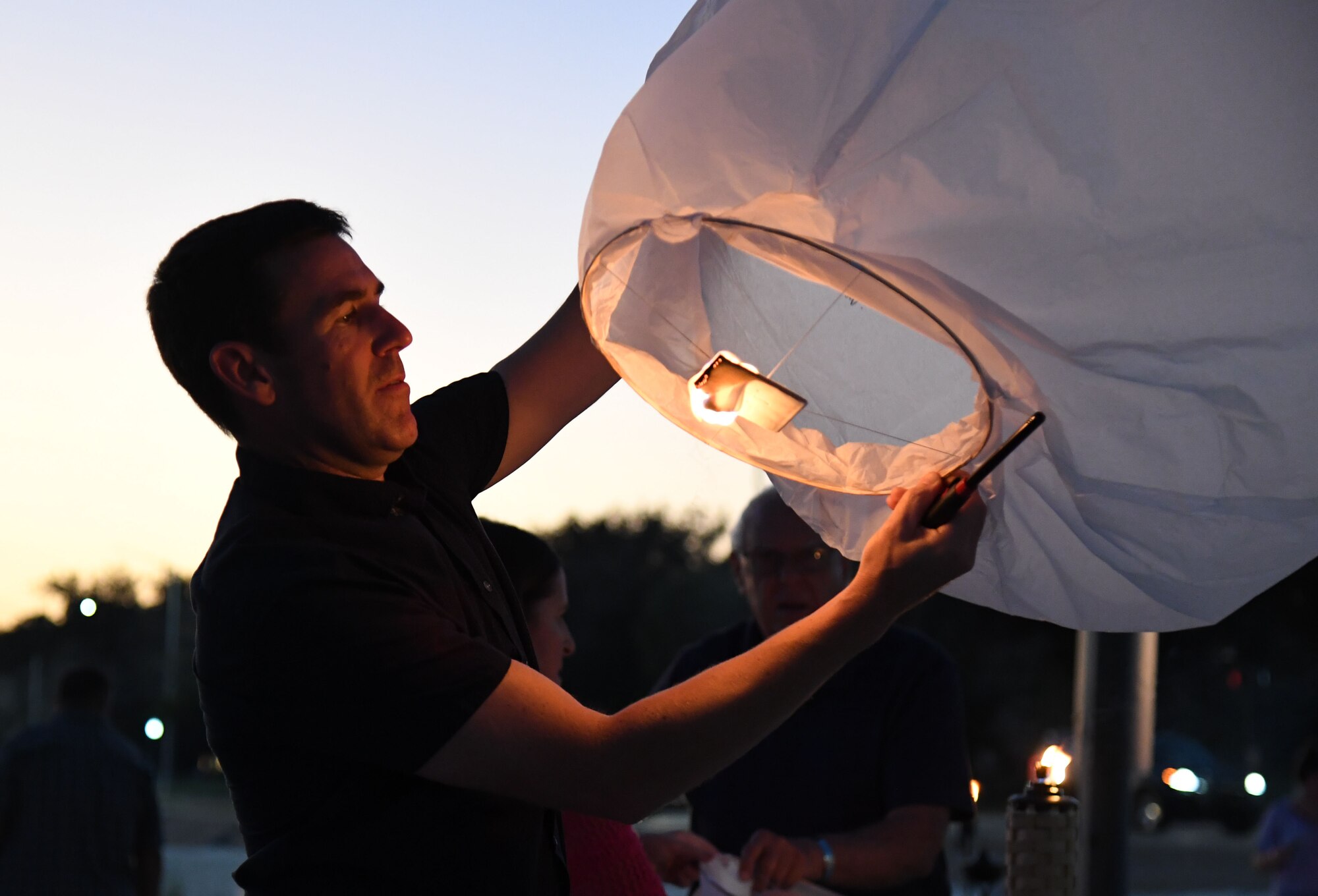 U.S. Air Force Col. Jason Allen, 81st Training Wing vice commander, lights a lantern during the Gold Star Families Sky Lantern Release on the Biloxi Beach, Mississippi, Sept. 23, 2022. The event, hosted by Keesler Air Force Base, included eco-friendly sky lanterns released in honor of fallen heroes. (U.S. Air Force photo by Kemberly Groue)
