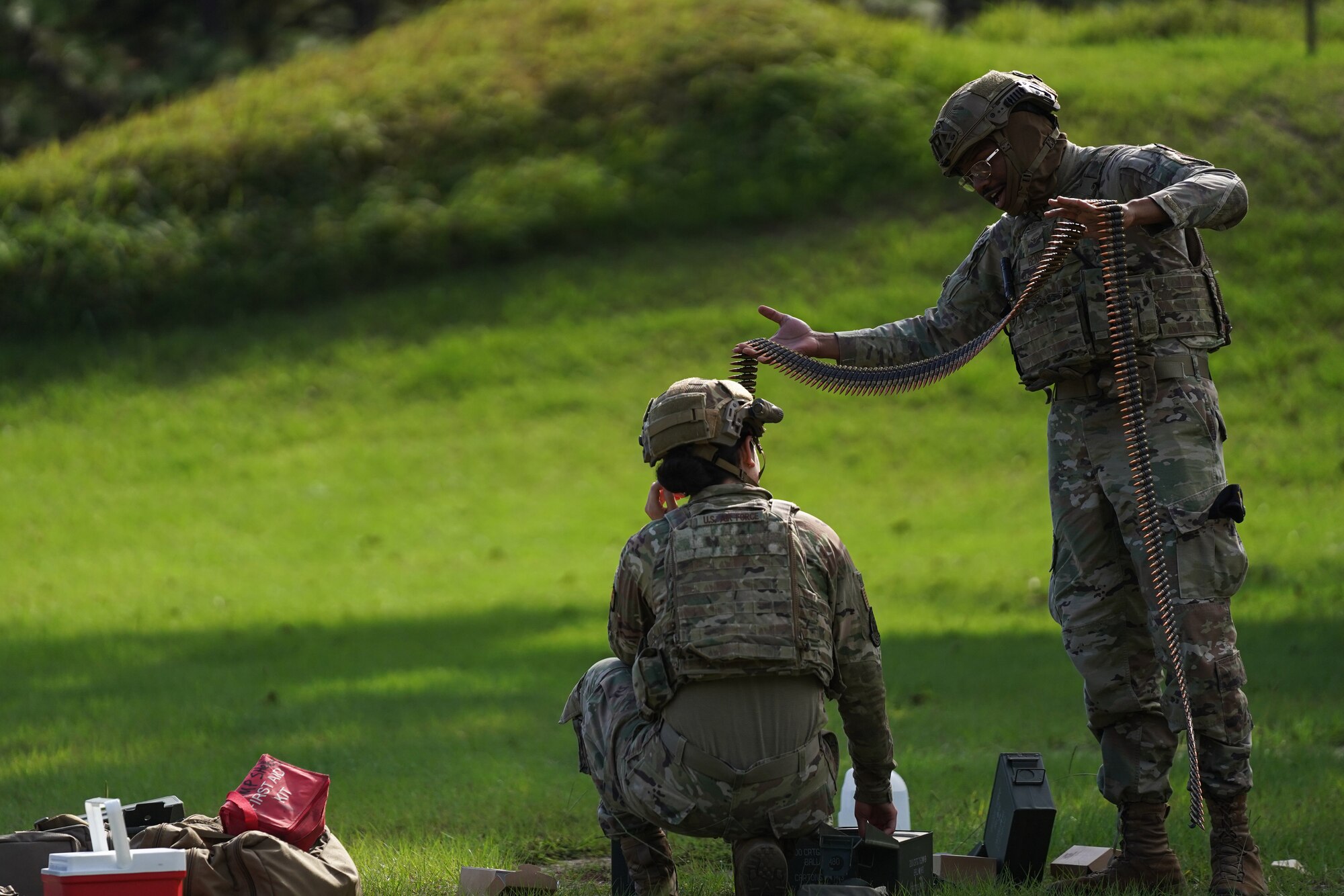 U.S. Air Force Airman Tyron Bennet and Airman Brianna Ramos, 81st Security Forces Squadron entry controllers, prepare ammunition on range 14 B at Camp Shelby, Mississippi, Sept. 23, 2022. Defenders rotate through firing different heavy weapon systems to hone their defense capabilities.