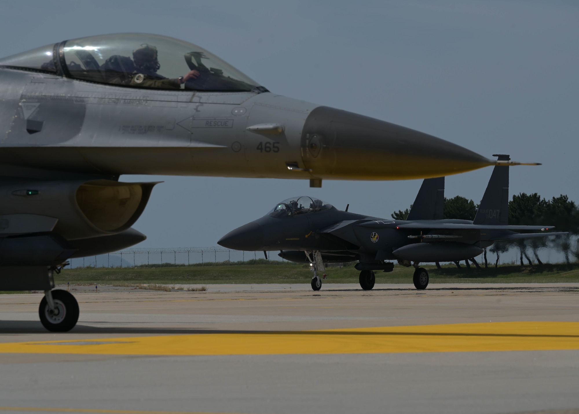 A U.S. Air Force F-16 Fighting Falcon assigned to the 8th Fighter Wing and a Republic of Korea Air Force F-15K Slam Eagle assigned to the 11th Fighter Wing, out of Daegu Air Base, ROK, taxi the flightline at Kunsan Air Base, ROK, Sept. 22, 2022. This bilateral training event, known as Buddy Squadron, is designed to increase interoperability between partner nations and promotes a free and open Indo-Pacific region. (U.S. Air Force photo by Staff Sgt. Isaiah J. Soliz)