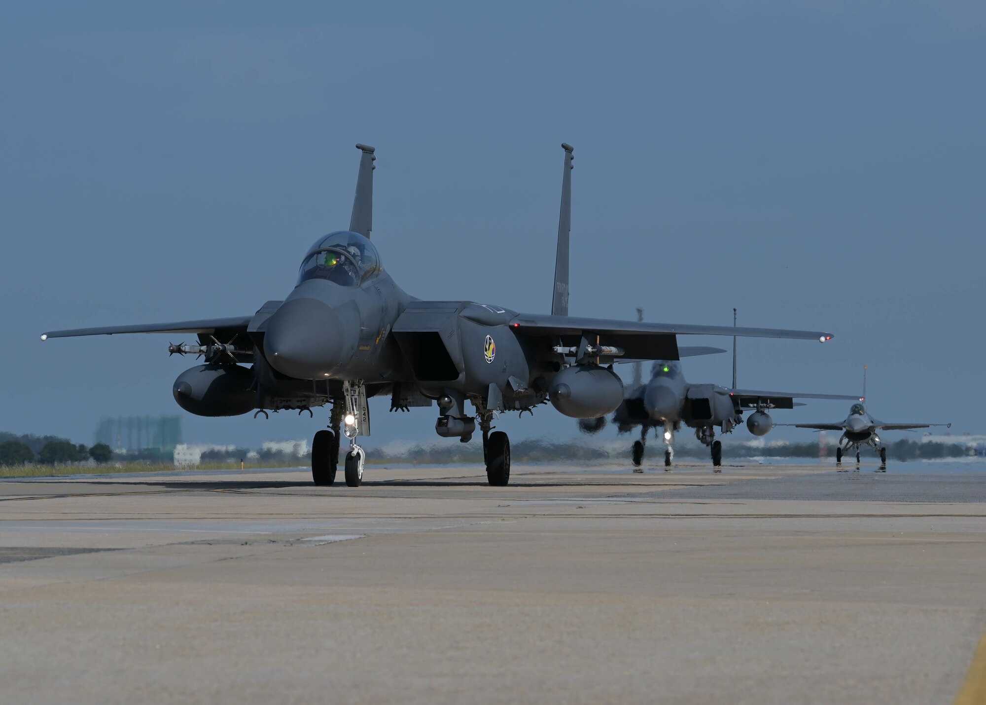 Two Republic of Korea Air Force F-15K Slam Eagles assigned to the 110th Fighter Squadron and an 8th Fighter Wing F-16 Fighting Falcon taxi on the flightline at Kunsan Air Base, Republic of Korea, Sept. 22, 2022. The two nations routinely fly training missions to increase interoperability between the two Air Forces in and around the Korean peninsula. (U.S. Air Force photo by Staff Sgt. Isaiah J. Soliz)