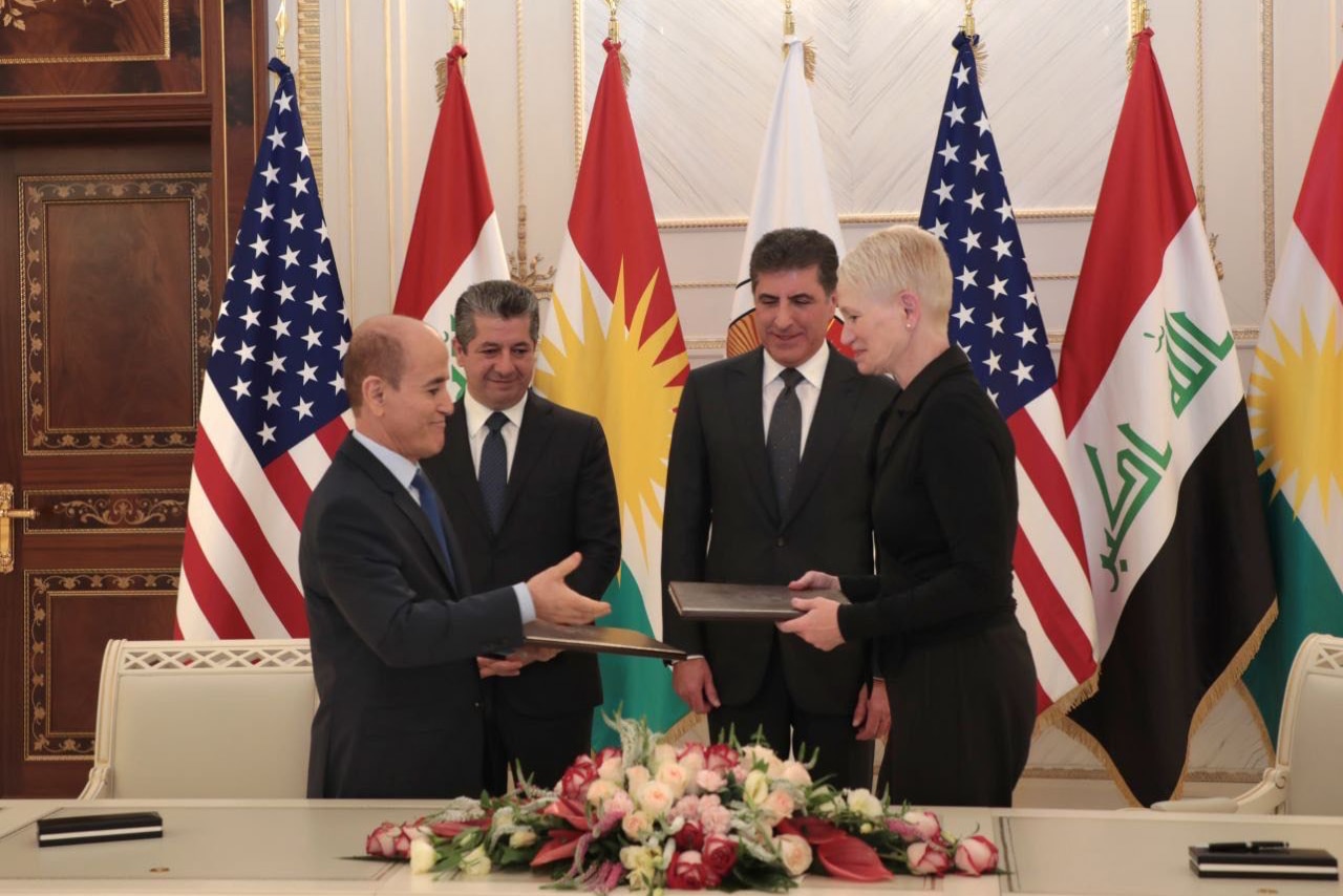 A man and woman face each other holding documents.