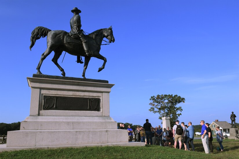 193rd Special Operations Wing Airmen huddle under the statue of Union General John Reynolds, the first general killed in action at the Battle of Gettysburg, during a tour given by the Army War College in Gettysburg, Pennsylvania September 19, 2022.