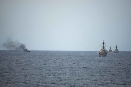 Ships sail next to a target that has been struck.