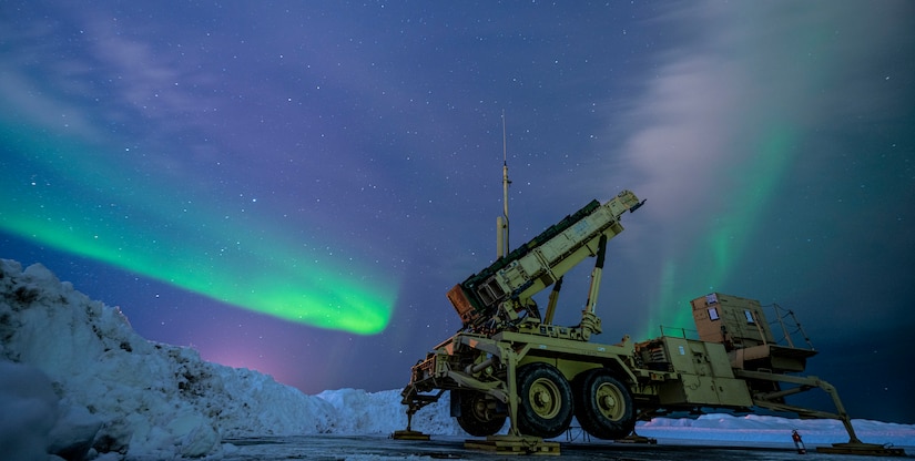 The northern lights paint the sky behind a missile launcher in Alaska.